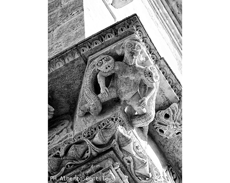 Cattedrale di Foggia, particolare del cornicione: un giovane imberbe azzannato da due serpenti.